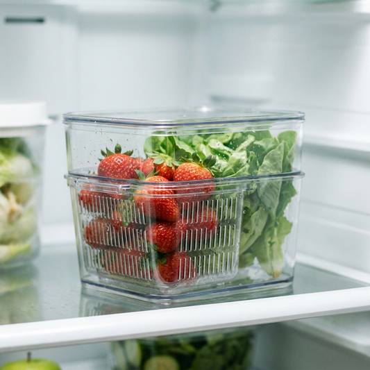 Strawberries and greens fresh in a strainer container
